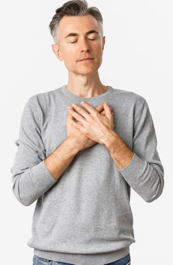 hombre de mediana edad con las manos en el pecho respirando